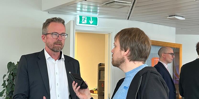 Geir Røsvoll, i dress, er avbildet på et presseseminar hos Unio nå nylig. Han intervjues av en journalist som tar opp samtalen. 