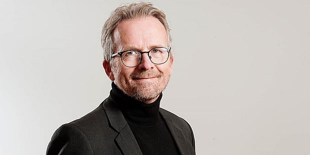 Portrettbilde av Geir Røsvoll som ser smilende mot kamera