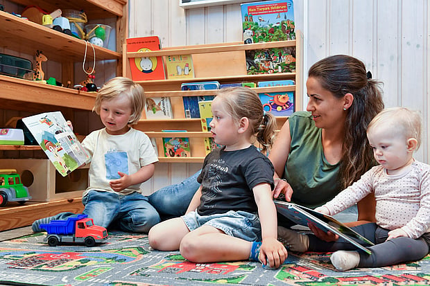 Foto av kvinnelig barnehagelærer som er i lek sammen med tre barn