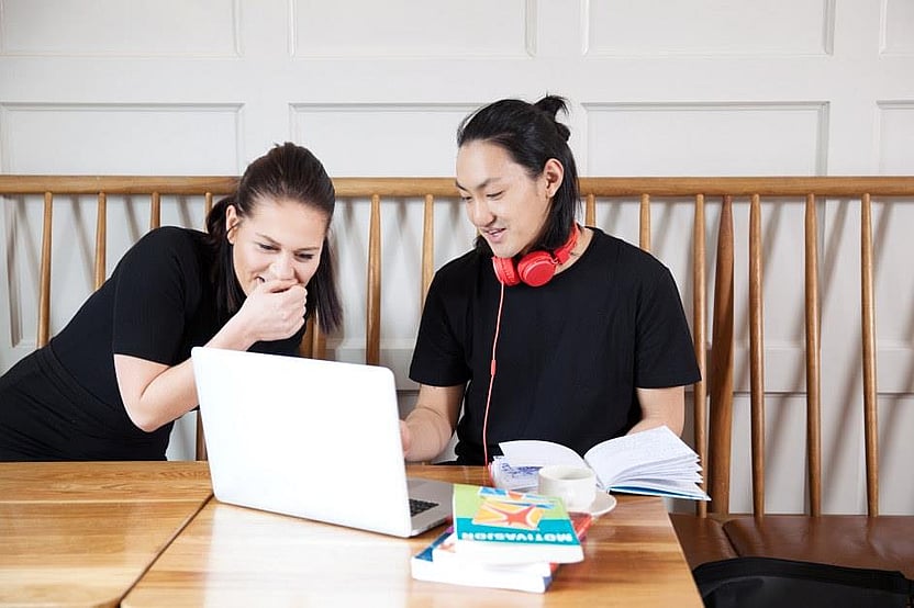 To studenter som sitter å jobber på lapptopp. Foto