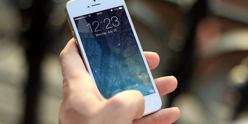 Nærbilde av hvit iPhone som noen holder i hånda