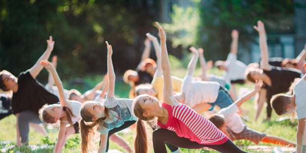 Barn som gjør yoga på en plen