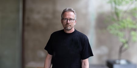 Halvnært bilde av Geir Røsvoll, ikledd sort T-skjorte.