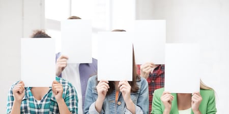 Bildet viser fem anonymiserte studenter eller lærere som står med et ark foran ansiktene sine.