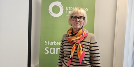 Bilde av Torill Beitdokken foran en rollup