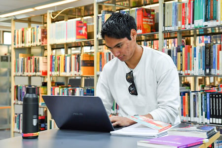 Student på biblioteket på universitetet / høyskolen. Illustrasjonsfoto