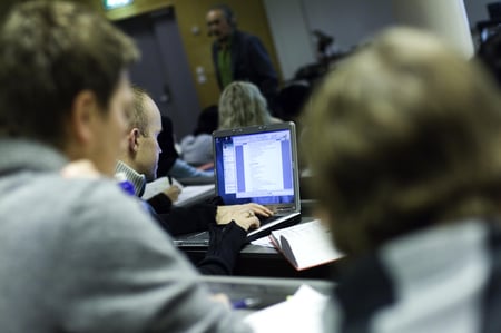 Elever sitter i klasserom med pc. Foto.