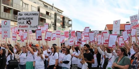 Streikende i Lillestrøm med mange plakater som viser misnøyen med KS.