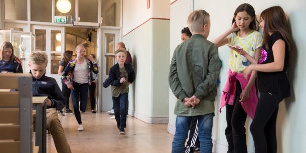 Elever i grunnskolen ute i gangen utenfor klasserommet.