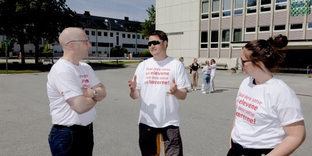 Foto av to streikende som snakker med Steffen Handal.