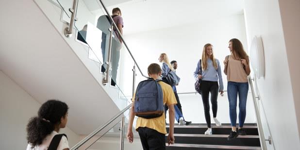 Elever som går i en trapp i en skolebygning. Foto.