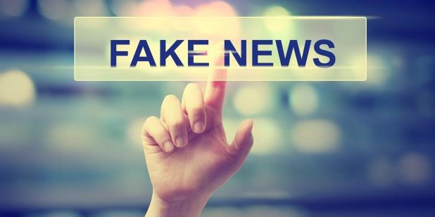 Illustrasjonsbilde av hånd som klikker på et skilt med "Fake news"