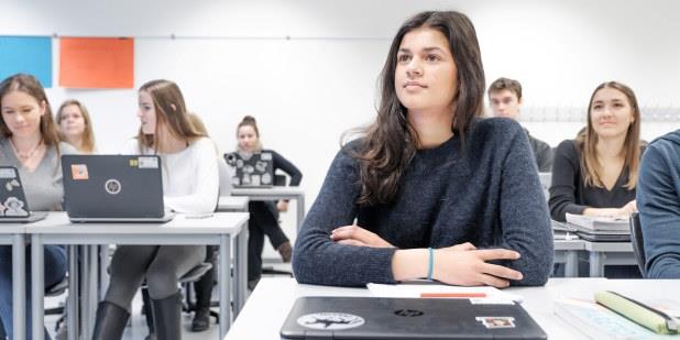 Ungdommer som sitter ved pultene i et klasserom. Foto.