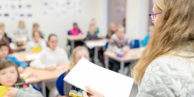 En lærer som står foran en klasse på barneskolen. Foto.