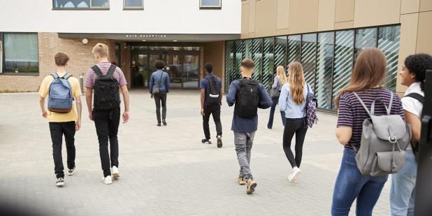 Ein gruppe elevar på veg inn i skolebygget. Illustrasjonsfoto.