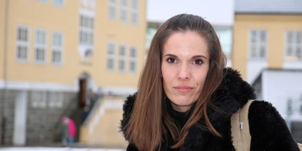 Bilde av Maren Songe-Møller foran en skole. Foto. 