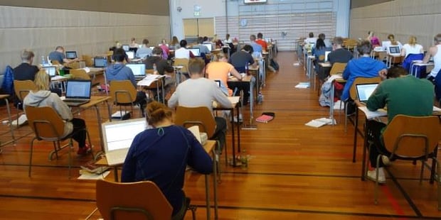 Eksamenslokale for elever i videregående i en gymsal . Foto