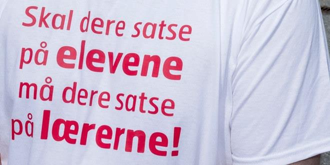 Bilde av en t-skjorte med teksten "Skal dere satse på ELEVENE må dere satse på LÆRERNE".