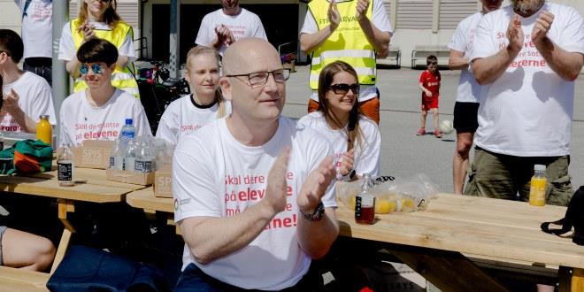 Foto av Steffen Handal fra juni da streiken startet i Bergen. Han sitter sammen med streikende og klapper til en appell. 