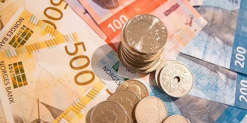 Bilde av sedler og mynter av norske kroner. 